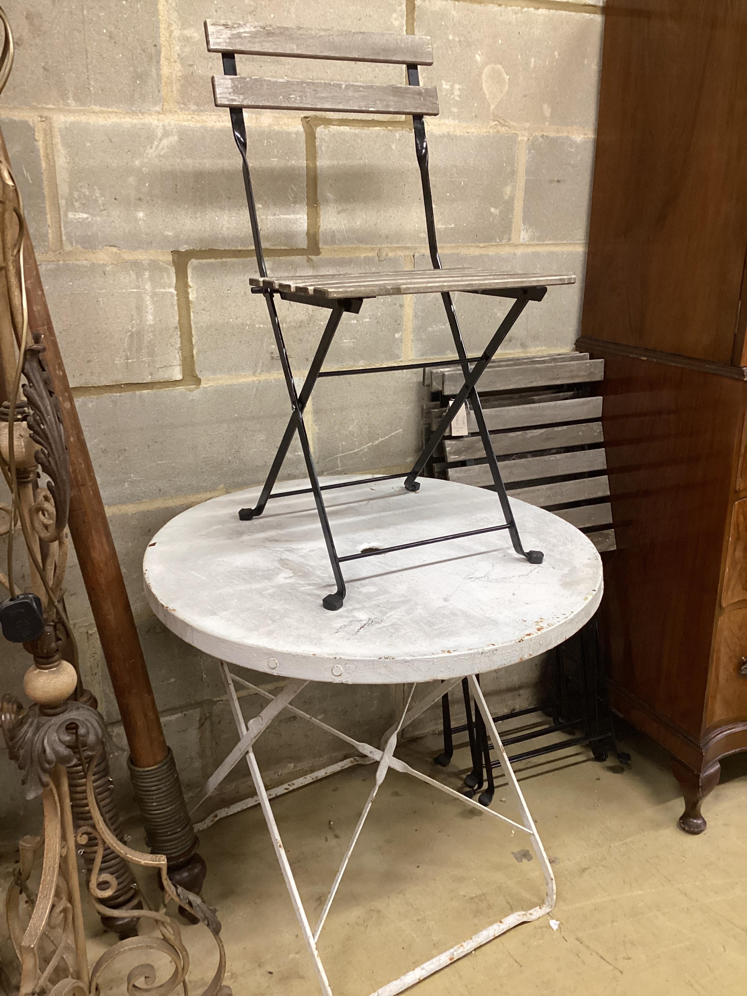 A circular painted metal folding garden table, diameter 74cm, height 68cm and four folding slatted garden chairs